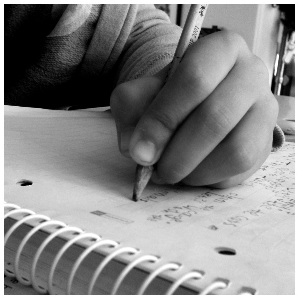 A hand writing notes in a notebook